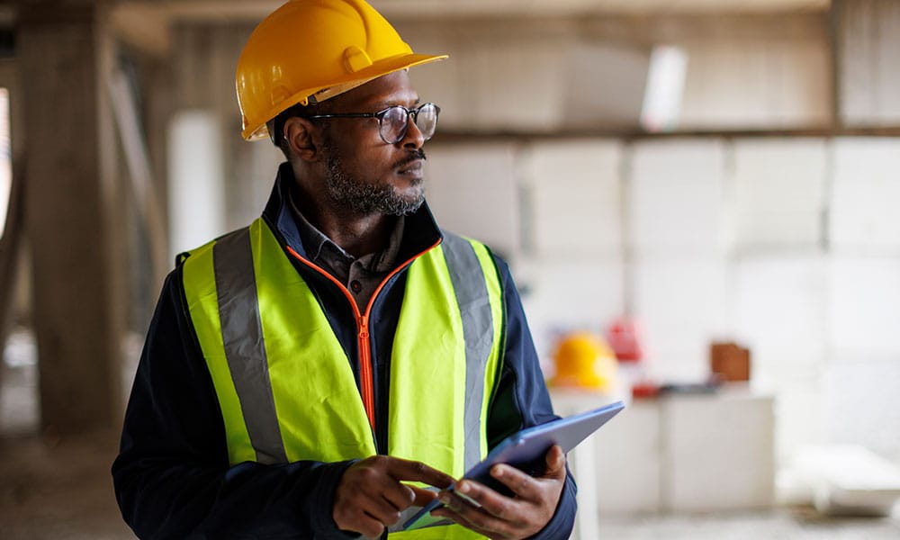 worker ensuring that his construction site in San Diego is in compliance with environmental real estate laws