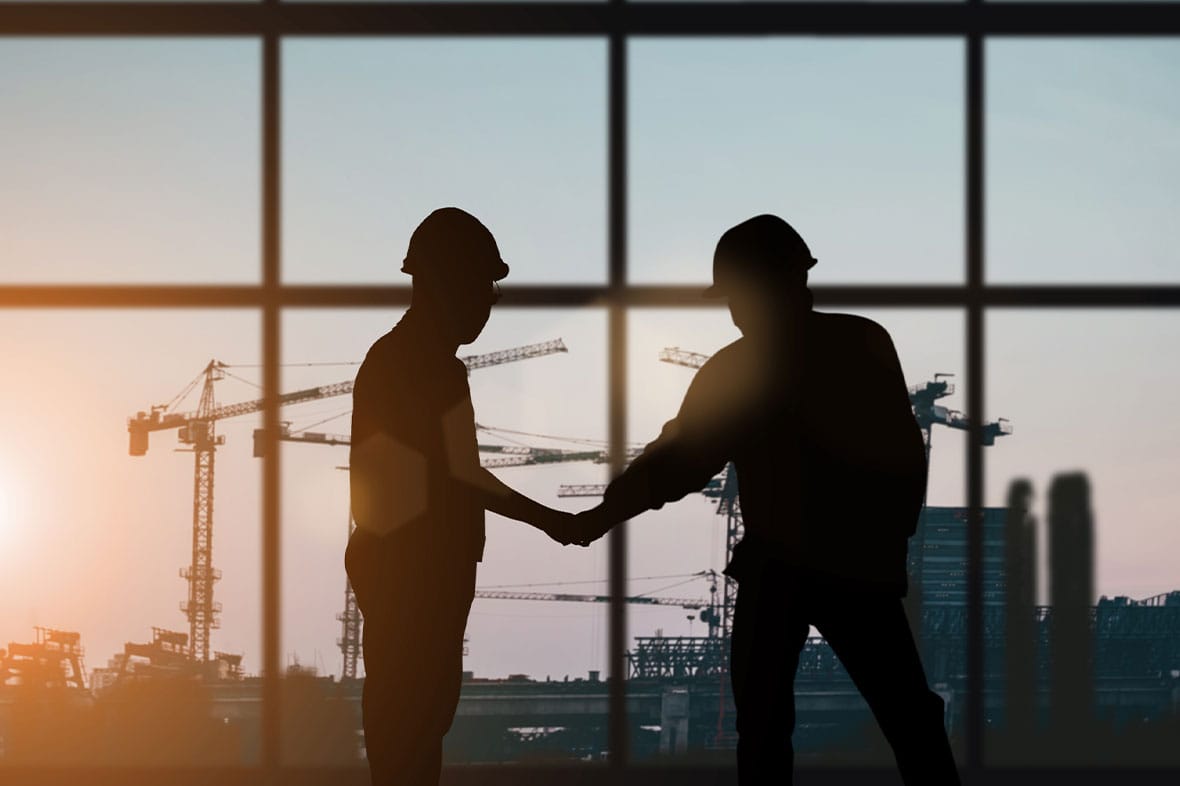 workers shaking hands on a construction site in los angeles