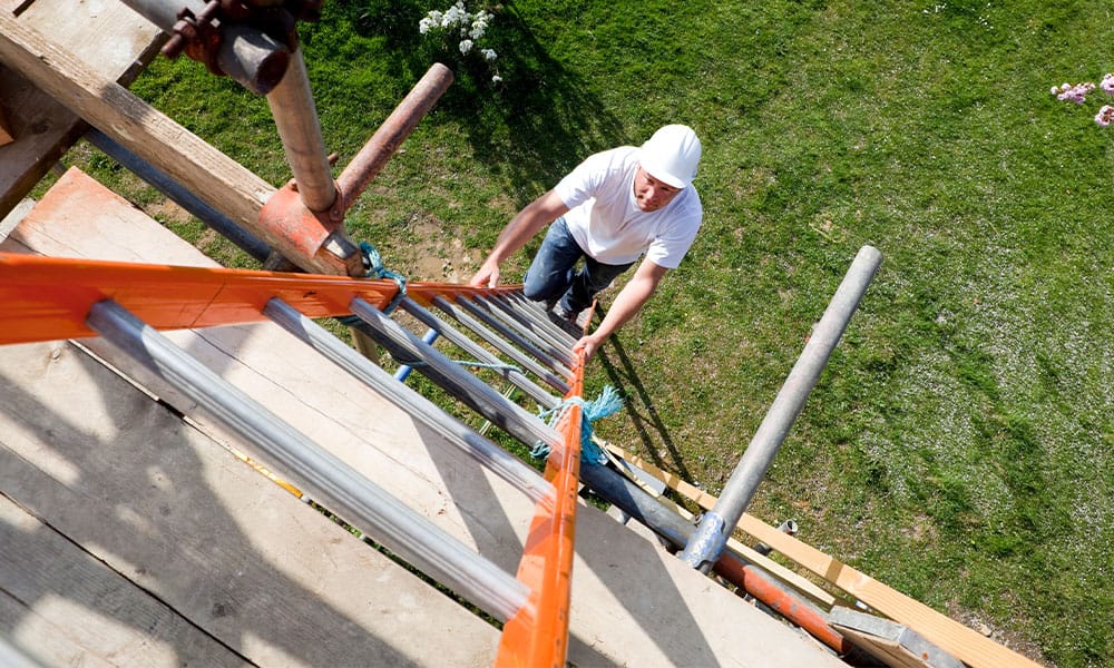 worker climbing a ladder on a San Diego construction site before falling
