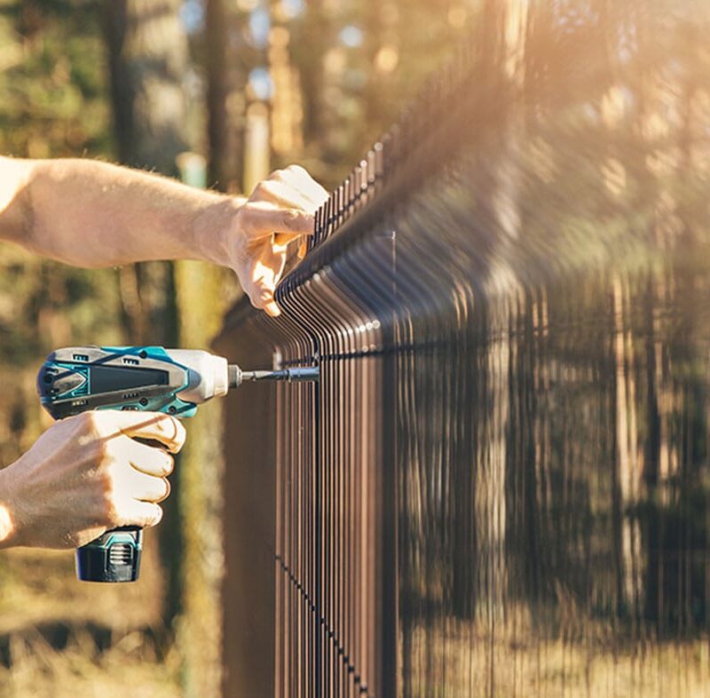 man working on his fence on his property line in San Diego, CA